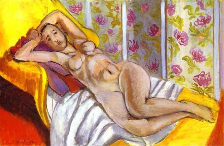 A nude woman reclines diagonally on a bright yellow divan with violet pillows and a white sheet, set before vertical panels of pale floral wallpaper; soft Mediterranean light models the magnolia-toned body, creating a serene, decorative interior.