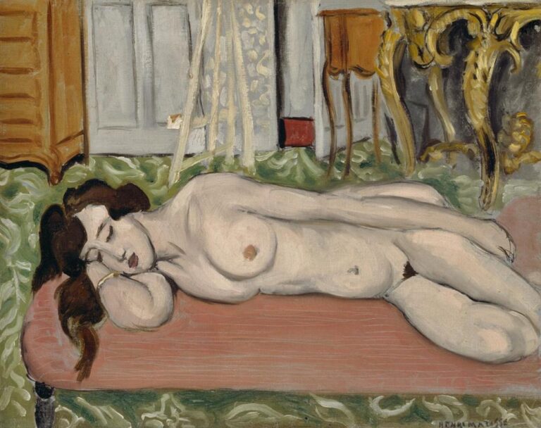 A nude woman sleeps on a low pink couch in a painter’s studio, surrounded by a green patterned carpet, pale doors, an easel, an orange cabinet, and a gilded rococo console; soft flesh tones, clear contours, and shallow space typify Matisse’s style.