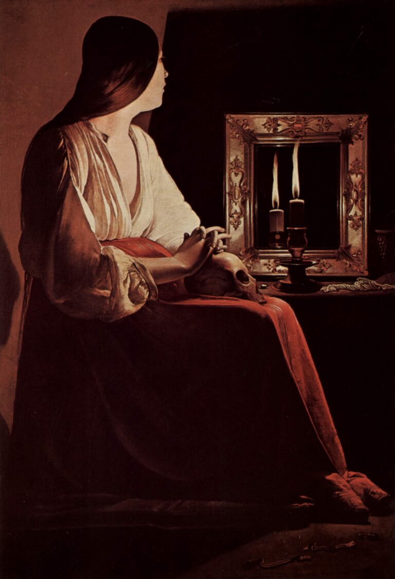 Candlelit interior with the Magdalene seated in profile, hands folded over a skull on her lap; on a table a single candle burns before a framed mirror that reflects a second flame, with pearls and a rosary resting in shadow.