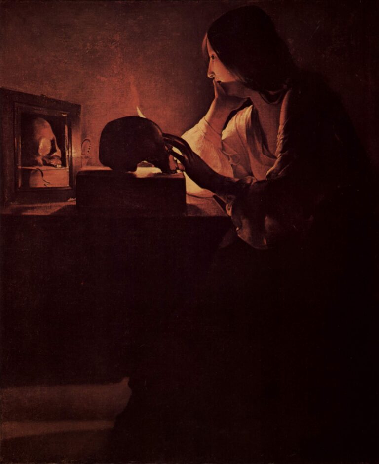Candlelit Magdalene sits in profile at a table, cheek in hand, fingertips resting on a skull before a small flame; a mirror at left reflects the skull, while most of the room falls into deep shadow and her white sleeve glows in warm light.