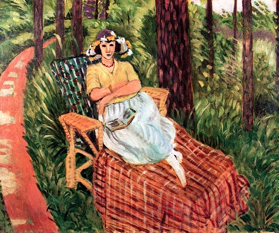 A woman with a flower garland sits calmly in a wicker armchair set on a plaid blanket amid tall grasses; a red path curves through slender trees behind her as soft yellows, blues, greens, and warm reds create a serene summer scene.