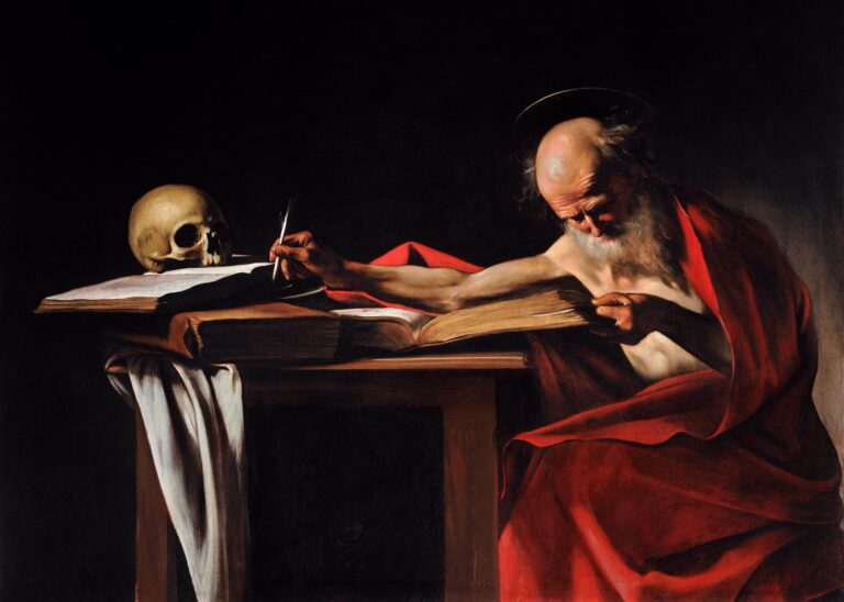 In a dark room, Saint Jerome sits in a red mantle at a wooden table, stretching his arm to write with a quill on a bright page beside a skull, while his other hand holds open a large book; a strong side light models the figures against deep shadow.