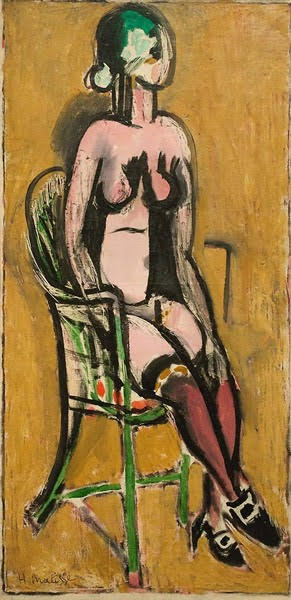 Tall, narrow canvas showing a nude woman seated on a green wicker chair before an ochre ground; her body is defined by thick black contours, violet stockings and black-white shoes, and a mask-like face with touches of green, painted in simplified planes by Henri Matisse.