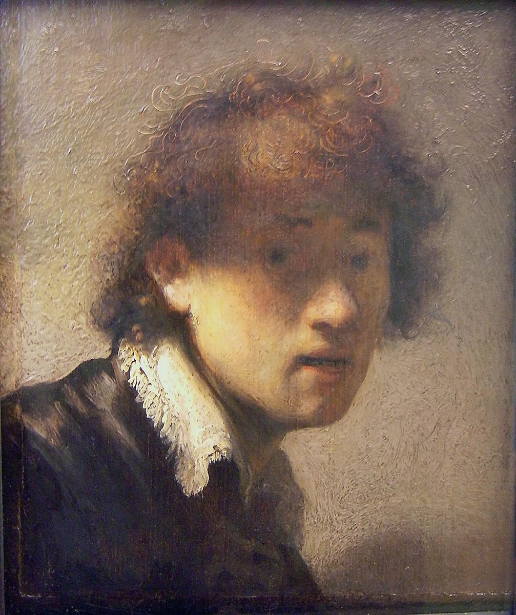 A young Rembrandt fills the frame in close-up, his copper curls catching light, lips slightly parted, and a bright lace ruff under his jaw; the head emerges from a pale, textured background with warm chiaroscuro.