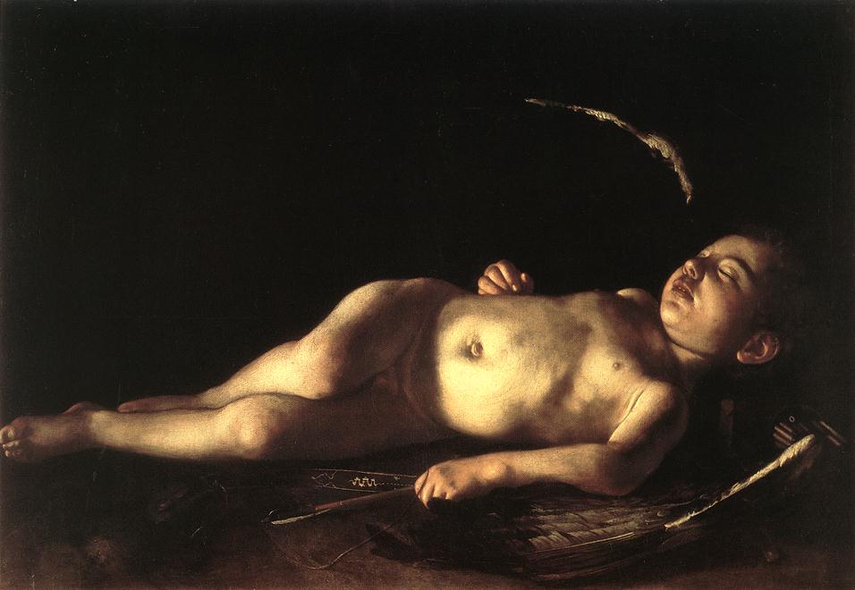 A nude child with small wings sleeps on a dark surface under raking light, his bow, arrows, and feathers lying unused nearby as deep shadow fills the background.