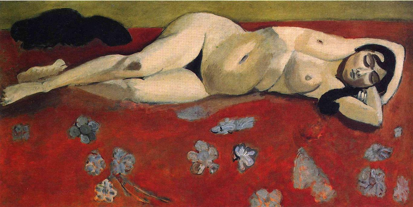 A long horizontal canvas by Henri Matisse showing a nude woman reclining across a deep red patterned carpet, head at right, feet at left, eyes closed; a narrow olive band tops the scene, and pale floral motifs float on the red while strong contours and soft modeling define the serene figure.