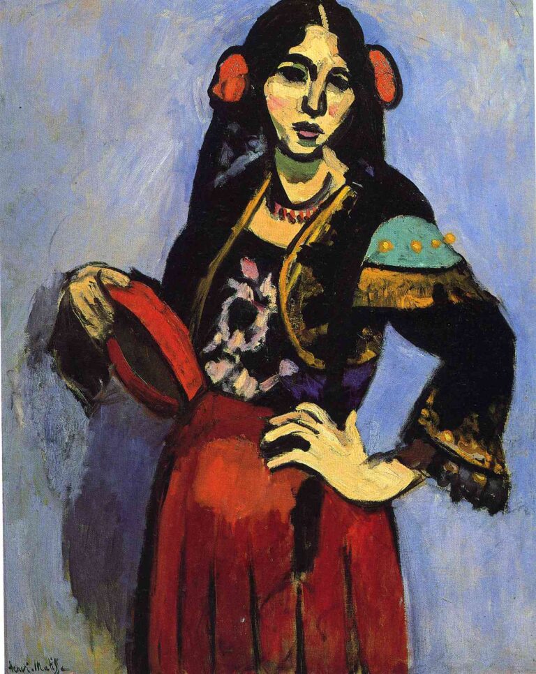 Three-quarter portrait of a woman in a black-and-gold jacket and red skirt, holding a red tamborine at her hip; red rosettes pin back her dark hair, a turquoise shoulder patch brightens the sleeve, and a cool blue background sets off bold contours in Henri Matisse’s 1909 “Spanish Woman with a Tamborine.”