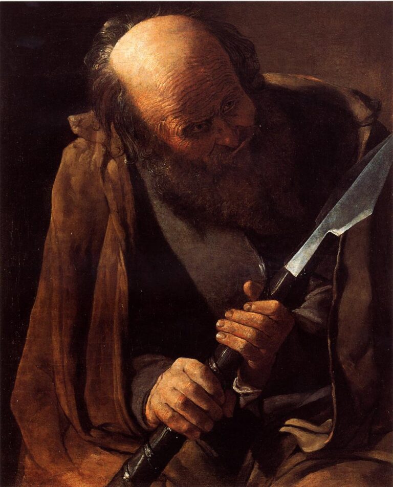 Half-length St. Thomas leans forward under warm light, bald crown and beard illuminated as his rough hands grip a black-shafted tool with a bright, chisel-like blade; a brown cloak drapes over a gray tunic against a simple two-tone wall.