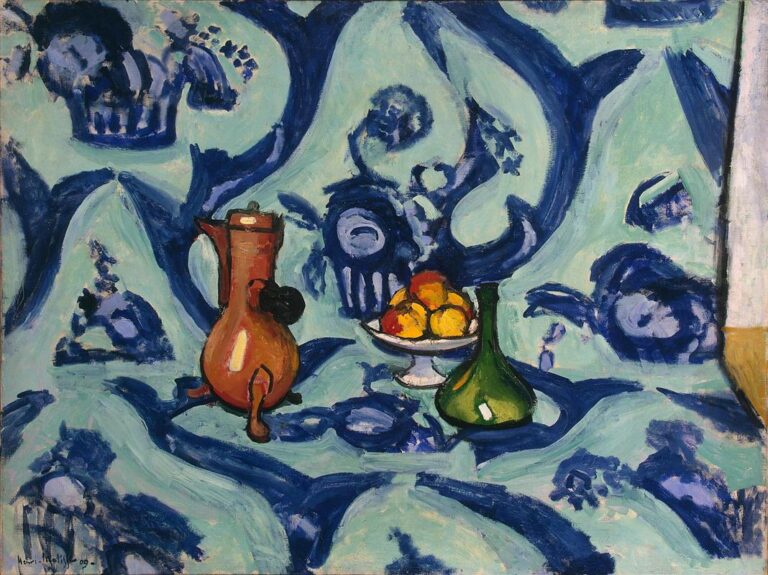 A copper coffee pot, a white pedestal bowl of yellow-red fruit, and a green glass bottle sit on a tablecloth whose deep blue arabesques sweep across a pale turquoise field and continue up the backdrop, creating a flat, decorative space in Matisse’s 1909 “Still Life with Blue Tablecloth.”