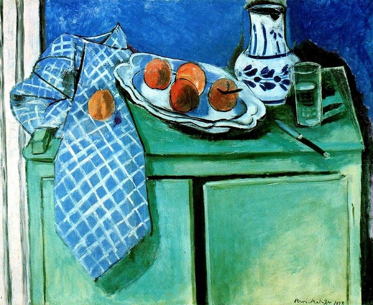 Mint-green sideboard with checked blue cloth hanging from the left door; white platter holding three peaches on the top; blue-and-white patterned pitcher and clear drinking glass at right; dark knife lying diagonally; deep blue wall behind; Henri Matisse, 1928.