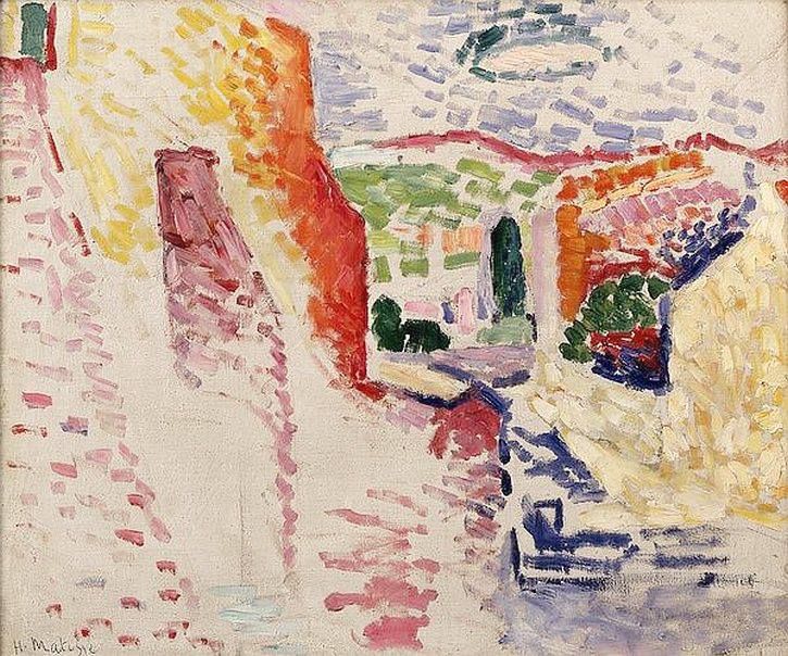 A Fauvist street scene by Henri Matisse showing a white, sun-blasted lane flanked by red-orange and yellow walls, a central opening onto green trees, blue-violet shadows at lower right, and a sky dotted with lilac and blue strokes.