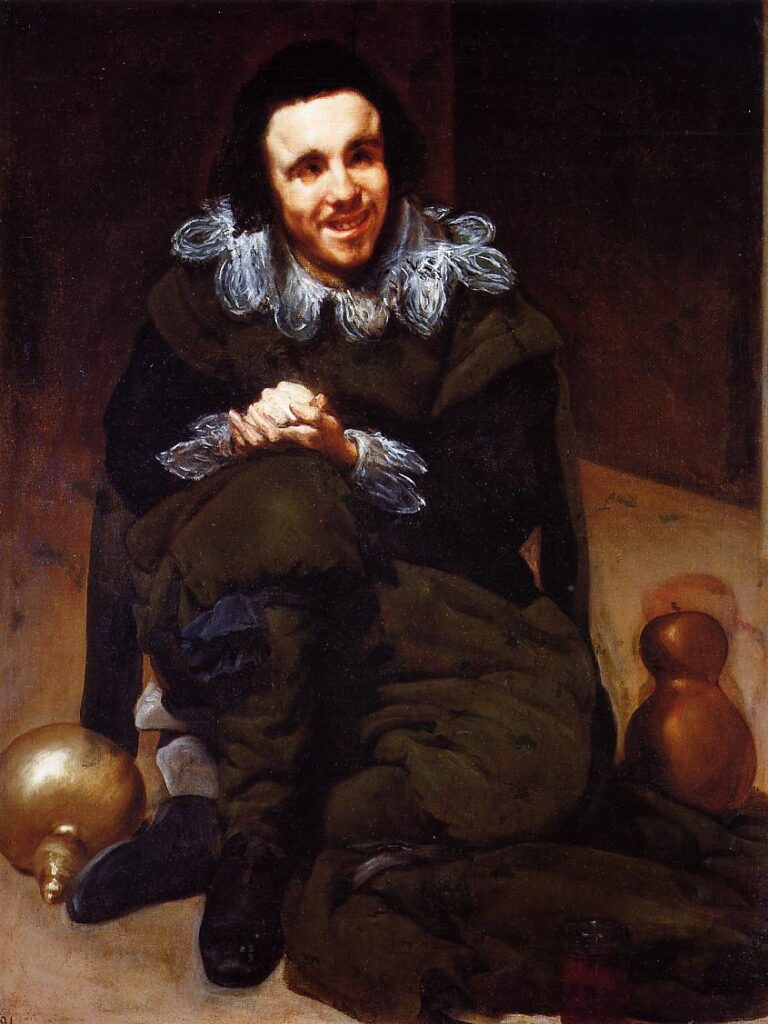 Seated jester in dark clothing with a lace collar smiles gently while clasping his hands, resting cross-legged on a floor between two glowing gourd-shaped vessels in a dim interior.