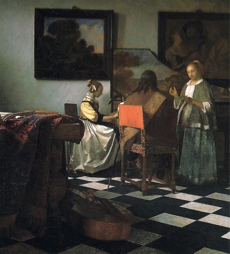 In a sunlit Delft room with a checkerboard floor, a man plays harpsichord as a seated woman tunes a lute and a standing woman sings from a book; a Persian carpet drapes a table at left, a viola da gamba lies on the floor, and two framed paintings hang on the back wall.