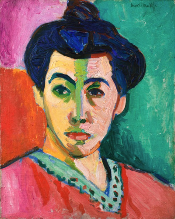 A Fauvist portrait by Henri Matisse showing Amélie Matisse frontally with a vivid green stripe down the center of her face, cool greens on the left side, warm pinks on the right, dark blue-black hair and brows, a coral garment, and magenta and teal background fields painted in broad, visible strokes.