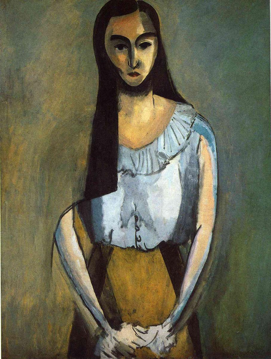 Frontal portrait of a standing woman with long dark hair, heavy brows, and hands clasped at the waist; pale blue-white blouse with gathered collar, ochre skirt, and green-gray atmospheric background; simplified planes and strong contours characteristic of Matisse’s 1916 style.