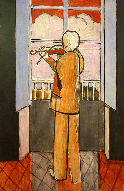 Interior by Henri Matisse (1918) showing a figure seen from behind playing violin before a large window; ochre suit, red tiled floor, blue shutters, red upper panes, balcony rail and distant view, drawn with bold black contours and simplified shapes.