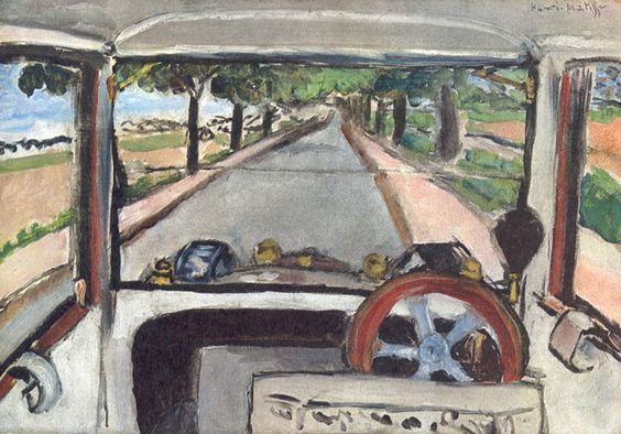 A 1917 painting by Henri Matisse showing the view through a car windshield: a gray road lined with trees recedes to a central vanishing point, framed by interior pillars and a large red-brown steering wheel at lower right; subdued grays, greens, and pink verges, with strong black contours, create a poised image of modern travel.