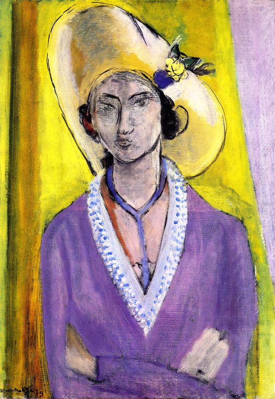 Woman shown frontally with arms folded, wearing an oversized yellow hat adorned with a small flower and a violet coat trimmed with dotted white; face drawn in spare dark lines; bright yellow background with a cool vertical strip at left; Henri Matisse, 1929.