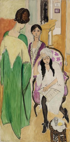 Tall, narrow interior by Henri Matisse showing three women in a room: a figure in a long green robe with her back to the viewer, a central woman facing forward in a violet-trimmed garment, and a seated woman in a pink-patterned chair holding a paper; a tea service sits at lower right and a small dark African figurine stands above a mantel in the background; flat color planes and strong black outlines create a calm, modern composition.