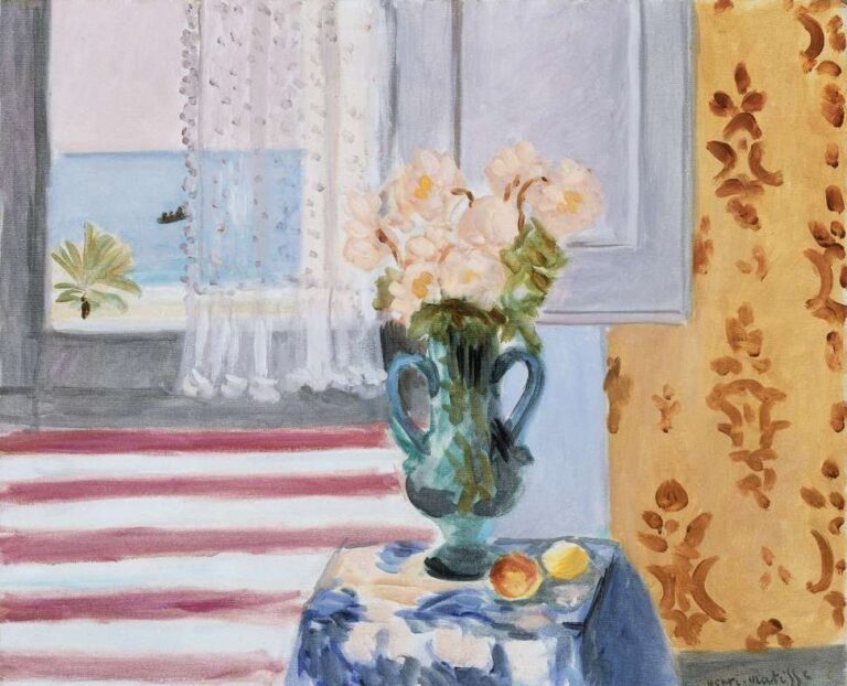 A blue-green two-handled vase of pale blossoms sits on a small table near an open window; red-and-white awning stripes, a glimpse of blue sea, a lace curtain, and a gold patterned wall frame the scene in a softly lit interior.