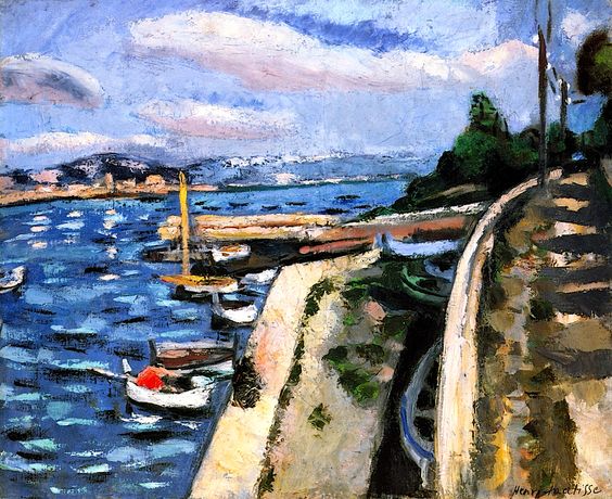 Curving promenade wall beside a small harbor with blue, wind-rippled water and moored boats; pale jetty, distant headland, and soft rose clouds under a bright sky, painted by Henri Matisse in 1925.
