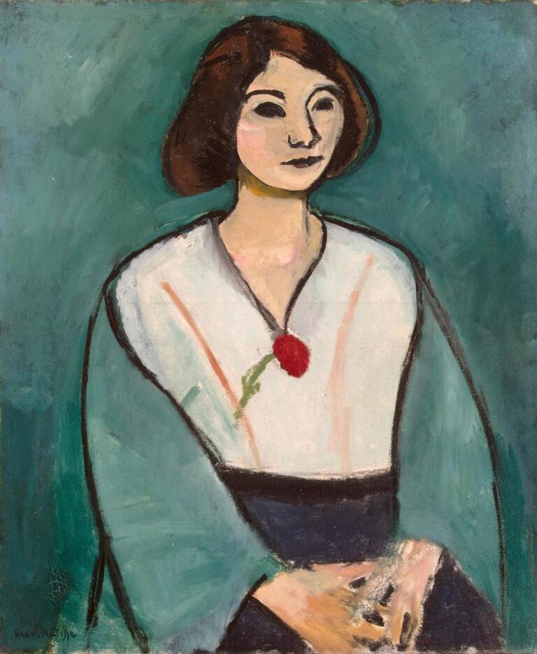 Half-length portrait of a woman seated before a teal background, wearing a pale tunic with a dark waistband and a green mantle; simplified features with almond eyes and short brown hair, hands resting in her lap, and a small red ornament at the chest, painted with bold contours in Matisse’s 1909 style.