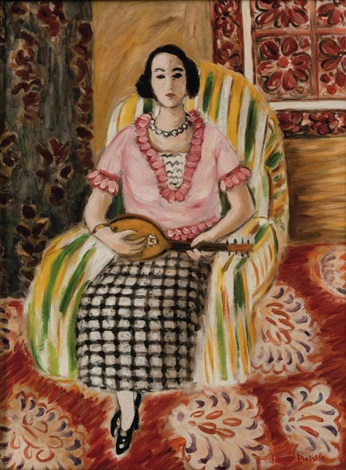 Front-facing woman seated in a green-yellow striped armchair, wearing a pink ruffled blouse and black-and-white check skirt, holding a small mandolin; red floral carpet fills the foreground and a red patterned wall panel appears at right; soft Mediterranean light and clear, balanced color typical of Matisse’s Nice period.