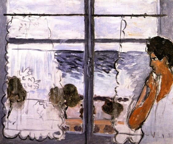 Interior view of a woman at right gazing toward a casement window with scalloped lace curtains; outside, bands of blue sea and gray sky; dark window mullions form a cross; soft, lavender-gray palette with loose, airy brushstrokes, 1920.