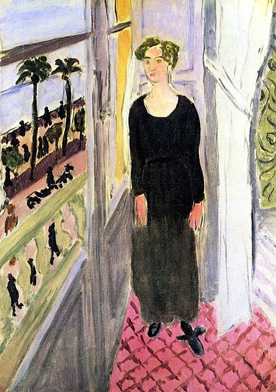 Interior with a woman in a black dress standing on a pink lattice floor beside an open window; beyond the balcony are palm trees, strolling figures, and a strip of blue sea, rendered in Matisse’s Nice-period style.