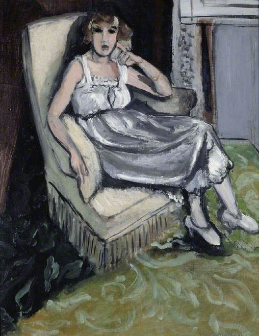 A 1917 painting by Matisse of a woman lounging in a pale, fringed armchair; she wears a white chemise and silver-gray skirt, one hand touching her cheek, crossed ankles in light shoes on a green patterned carpet; strong black contours, soft even light, and restrained colors create a calm, modern interior portrait.