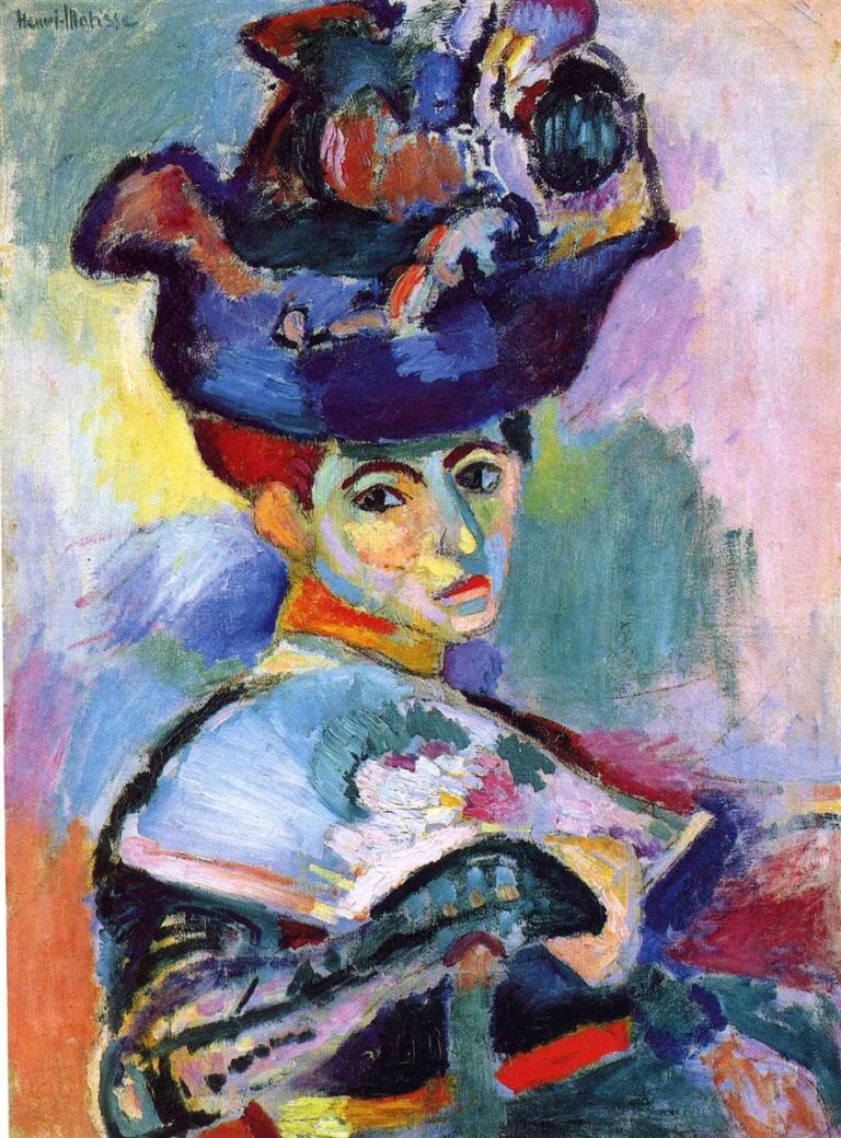 A Fauvist portrait of Amélie Matisse wearing a large violet-blue hat; her face is modeled with bold strokes of teal, coral, yellow, and green against a cool turquoise–lilac background, with a white floral accent and dark fan anchoring the lower right—painted by Henri Matisse in 1905.