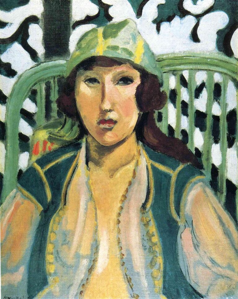 Half-length portrait of a woman in a green cap and teal “oriental” vest over a pale chemise, seated before a patterned screen and curved chair slats; cool blue-greens frame warm skin tones; bold black contours and soft, even light create a calm, shallow space.