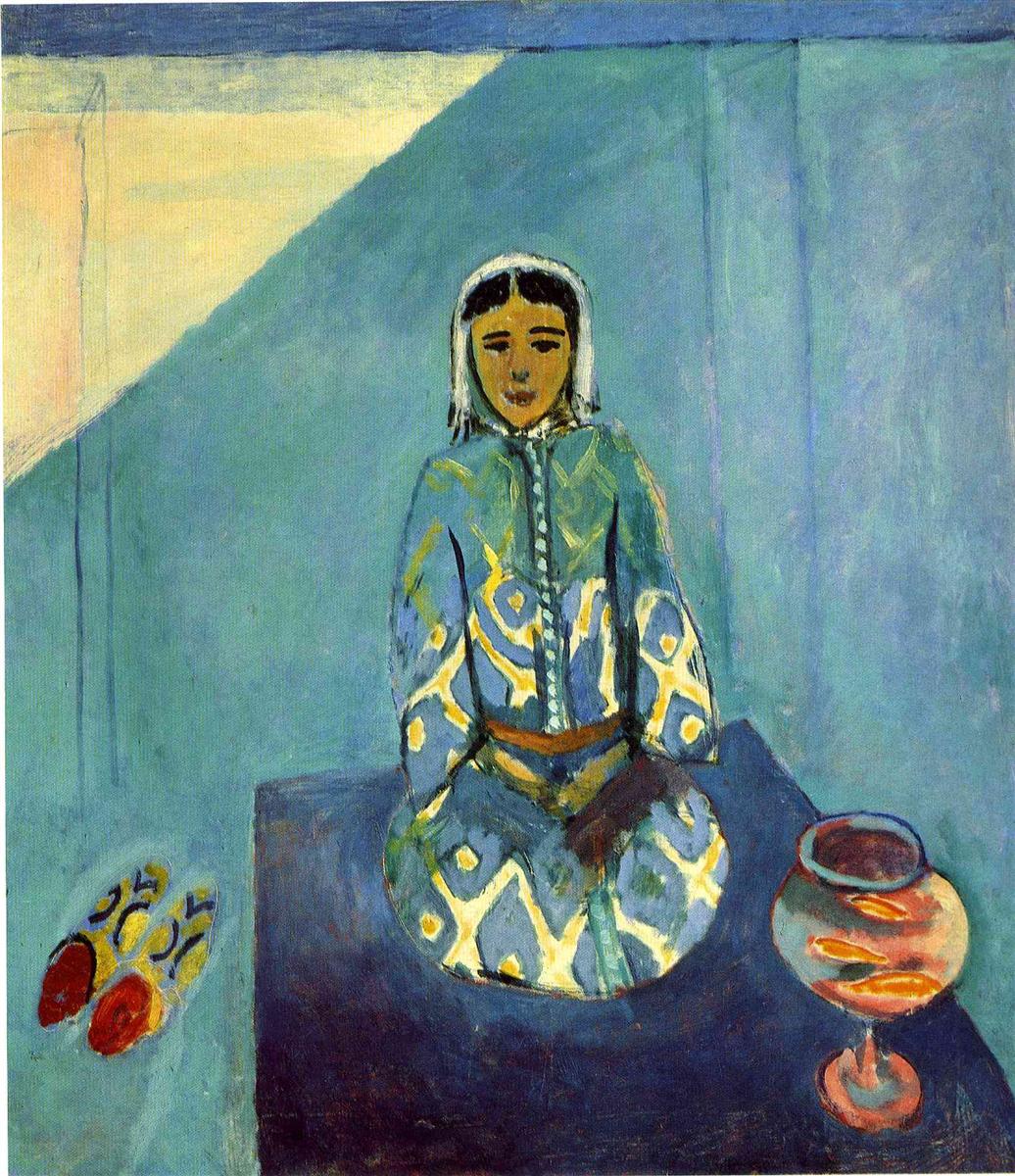 A 1912 painting by Henri Matisse showing a seated woman named Zorah on a blue terrace, wearing a patterned blue-green garment and headscarf, with red-tipped slippers on the left and a round goldfish bowl on the right, all set against flat blue walls with a triangular wedge of pale light.