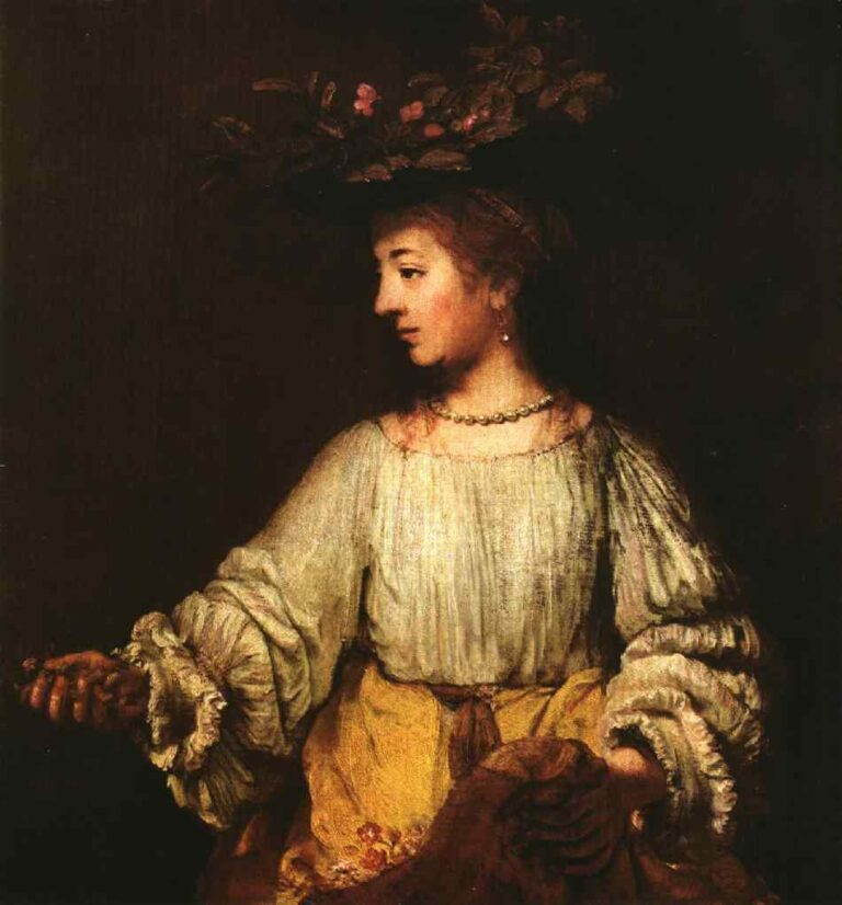 Half-length portrait of Hendrickje Stoffels in profile wearing a leafy flower crown, pearl necklace, light linen blouse with ruffled sleeves, and a golden apron, softly lit against a dark background with one hand extended and the other holding draped cloth.