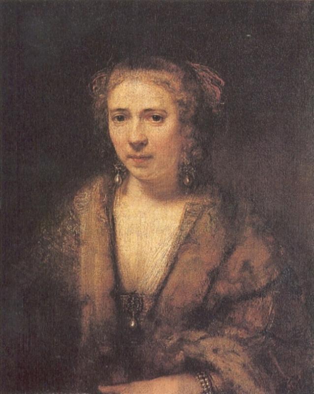 Softly lit portrait of Hendrikje Stoffels by Rembrandt: she faces slightly toward the light, wearing a fur-trimmed wrap with pearl earrings; her calm, attentive expression emerges from a warm brown background with delicate, painterly brushwork.