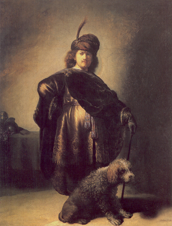 Full-length self-portrait of young Rembrandt in a turban and richly trimmed mantle, standing with a staff as a curly poodle sits at his feet; warm light from the left illuminates his face, silk tunic, gold tassels, and the dog against a subdued interior with armor on a side table.