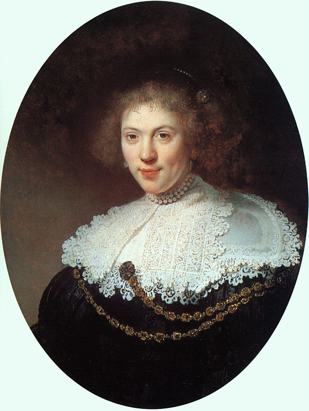 Oval portrait by Rembrandt of a young woman turned three-quarters, wearing a richly worked white lace collar, a double string of pearls, and a gold chain draped across a black dress, her softly lit face emerging from a dark background with a gentle, knowing smile.