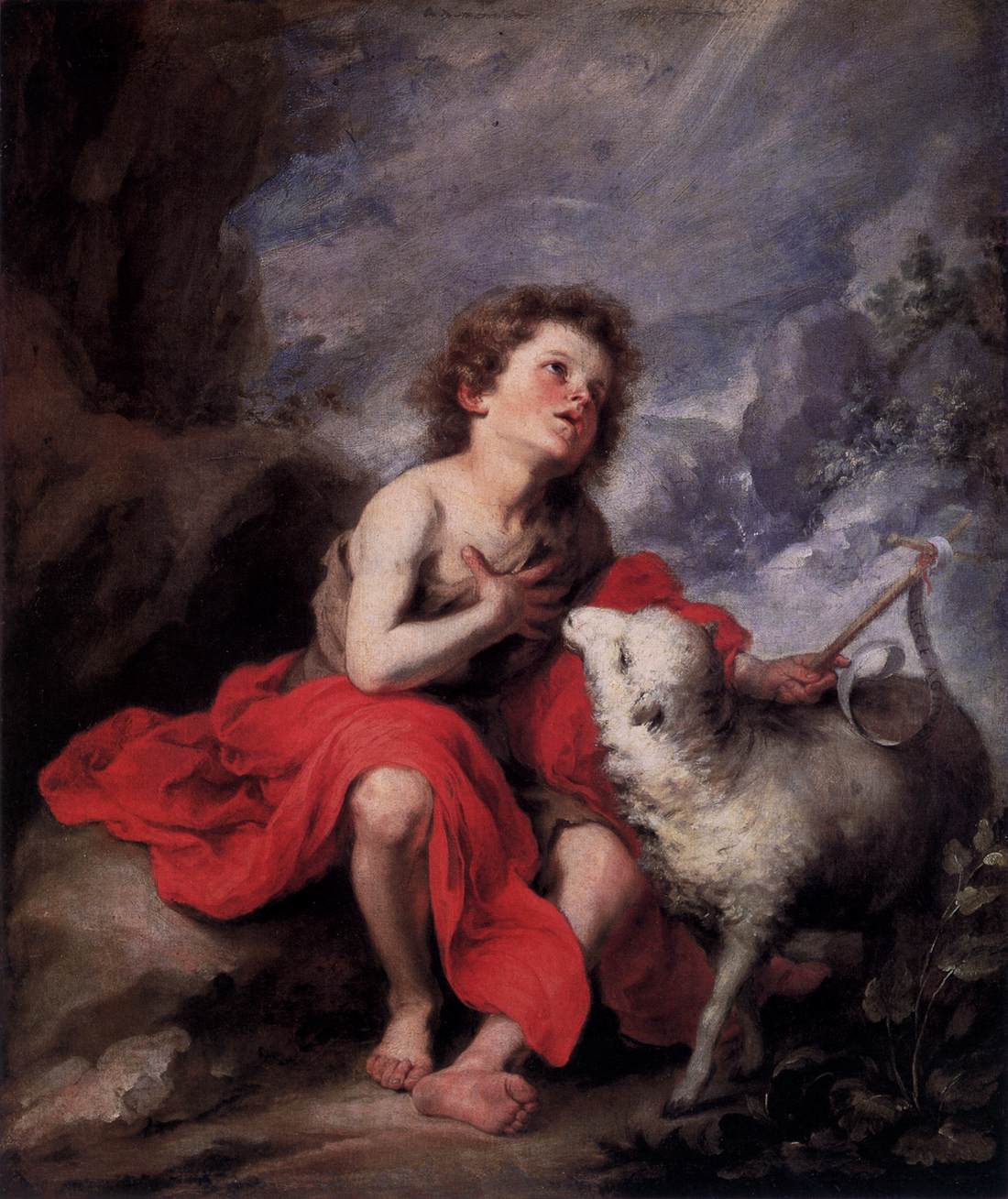 Baroque painting of a young St. John the Baptist seated barefoot on rocky ground, draped in a red cloak, one hand on his chest, gazing up toward a beam of light while a white lamb stands beside him.
