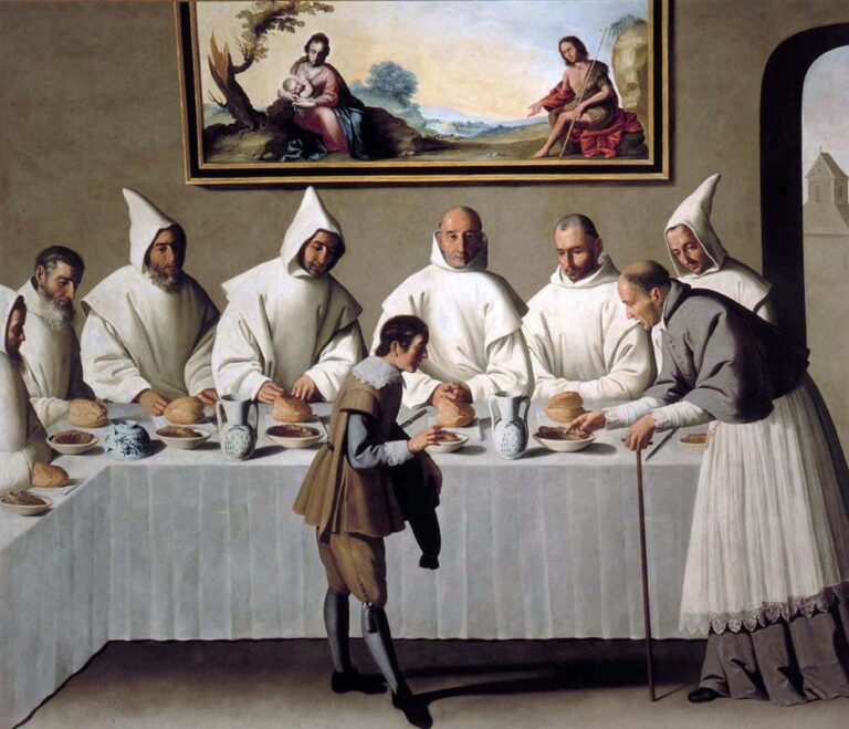 Carthusian monks in white habits sit in a refectory at a long white covered table set with bread, bowls of food and ceramic jugs, while an elderly bishop leans forward to offer a bowl to a kneeling young man, and a framed image of the Virgin, Child and St. John the Baptist hangs on the wall above.