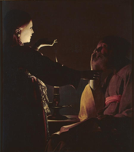 Dark interior painting by Francisco de Zurbaran showing Saint Joseph seated in shadow with an open book on his lap while a glowing child stands beside a candle, touching Joseph’s face and pointing upward, the figures dramatically lit against a deep black background.