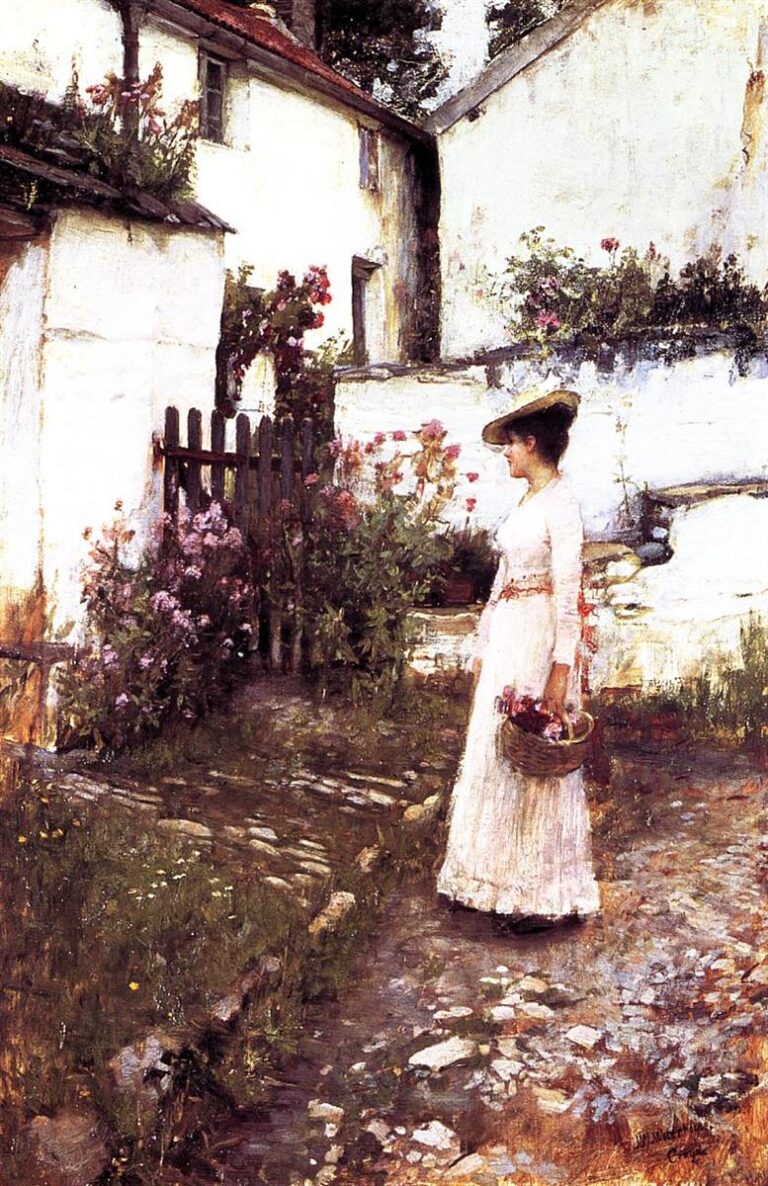 A woman in a long white dress and wide hat stands on a sunlit cobblestone garden path holding a basket of flowers, framed by white cottage walls, a dark gate, and lush blooming plants in a Devonshire garden.