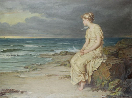 A young woman in a pale dress sits barefoot on coastal rocks, gazing left toward the sea under dark, clouded skies with gentle waves rolling toward a sandy beach.
