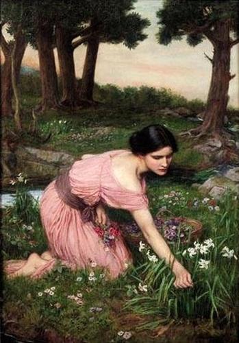 A young woman in a soft pink dress kneels in a spring meadow picking wildflowers beside a wicker basket, with trees and a small stream in the background, in John William Waterhouse’s 1910 painting “Spring Spreads One Green Lap of Flowers.”