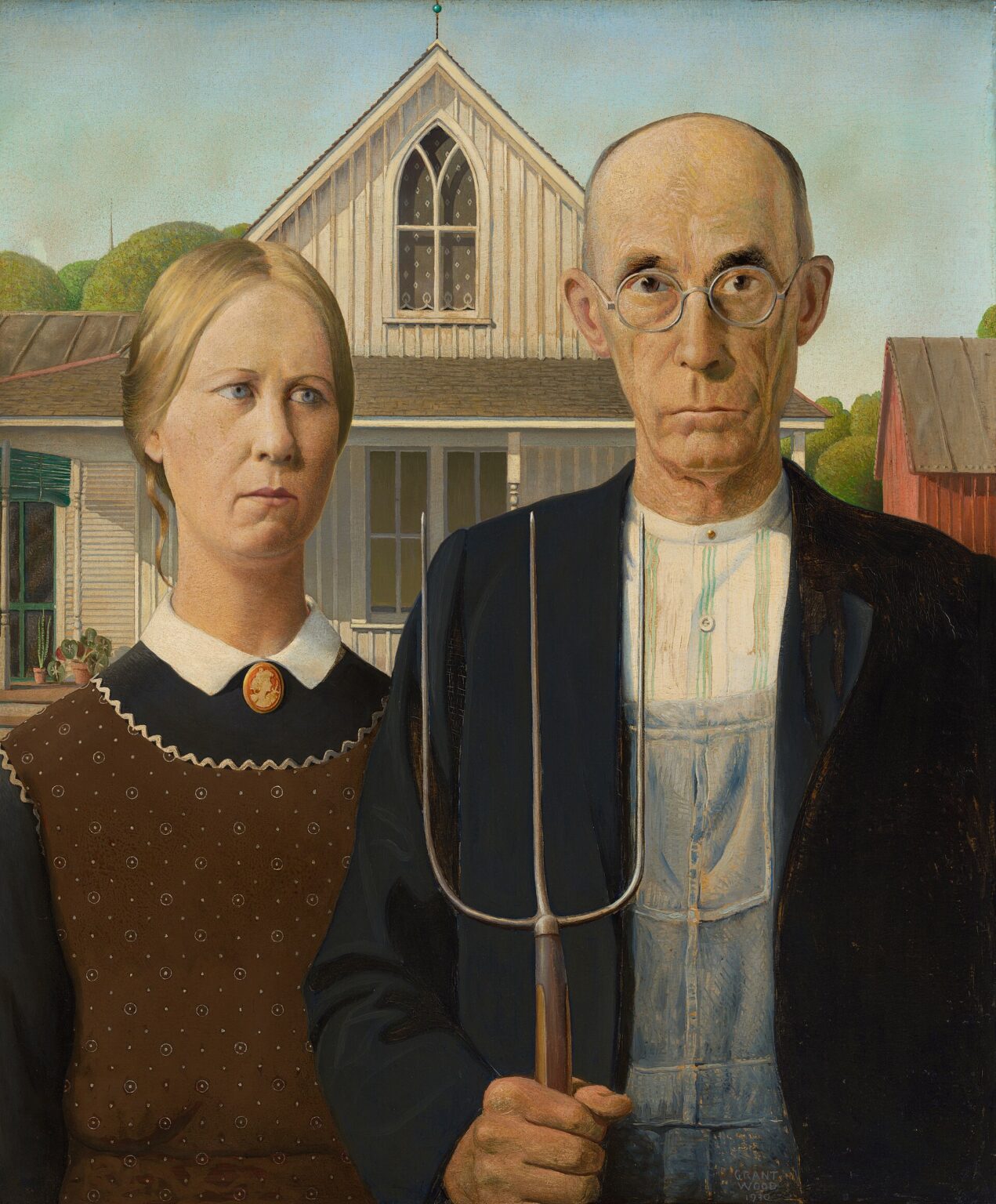Grant Wood’s “American Gothic” showing a stern farmer holding a pitchfork beside a solemn woman in front of a white farmhouse with a pointed Gothic window.
