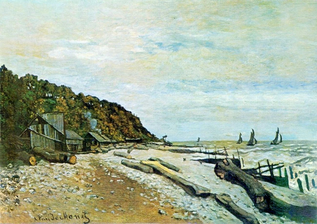 Claude Monet’s “Boatyard near Honfleur” shows a rough Normandy shoreline with wooden sheds, scattered logs, a tree covered slope, choppy water, and distant sailboats beneath a pale cloudy sky.