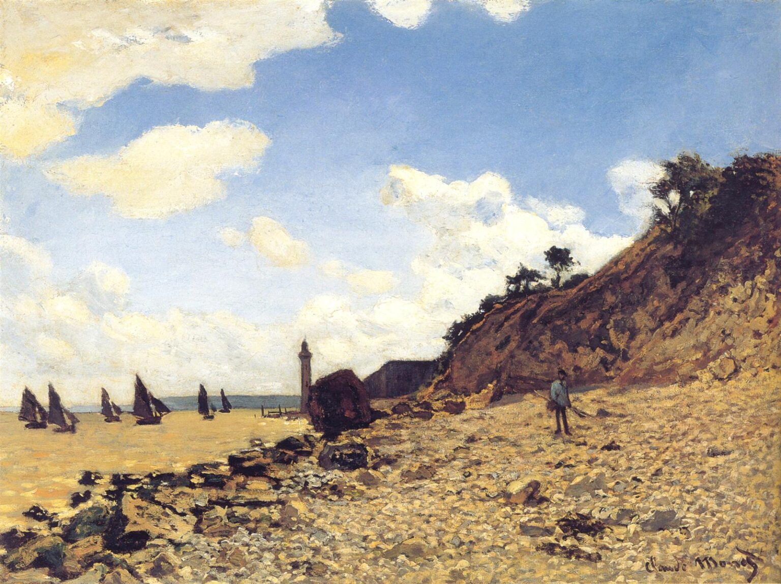 Claude Monet’s The Beach at Honfleur shows a sunlit pebbled beach in Normandy with dark sailboats on calm water, a steep cliff rising at the right, a small standing figure near the shore, and large white clouds drifting across a bright blue sky.